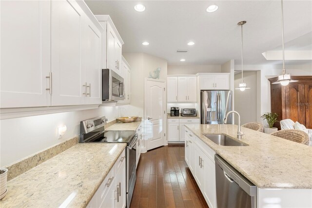 6936 White Willow Ct, Sarasota, FL 34243 - kitchen featuring an island with sink, white cabinets, a sink, stainless steel appliances, and dark wood-style floors