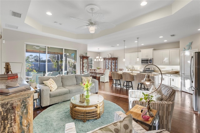 6936 White Willow Ct, Sarasota, FL 34243 - living area featuring a raised ceiling, dark wood-type flooring, ceiling fan with notable chandelier, and recessed lighting