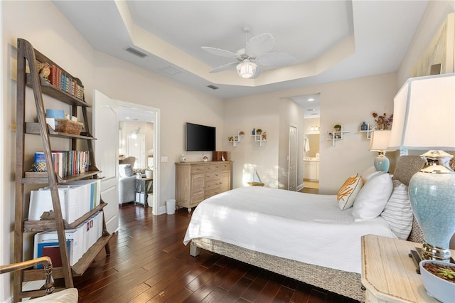 6936 White Willow Ct, Sarasota, FL 34243 - bedroom with visible vents, baseboards, a tray ceiling, and dark wood finished floors
