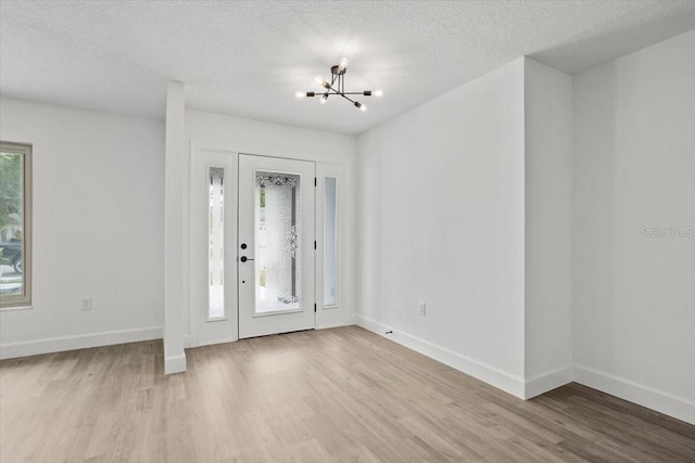 2881 48th Way E, Bradenton, FL 34203 - entrance foyer featuring a chandelier, light wood-type flooring, a textured ceiling, and baseboards