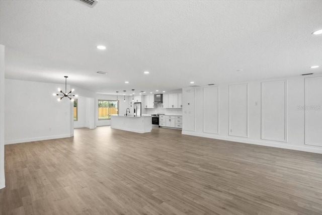 2881 48th Way E, Bradenton, FL 34203 - unfurnished living room featuring light wood finished floors, recessed lighting, and a notable chandelier