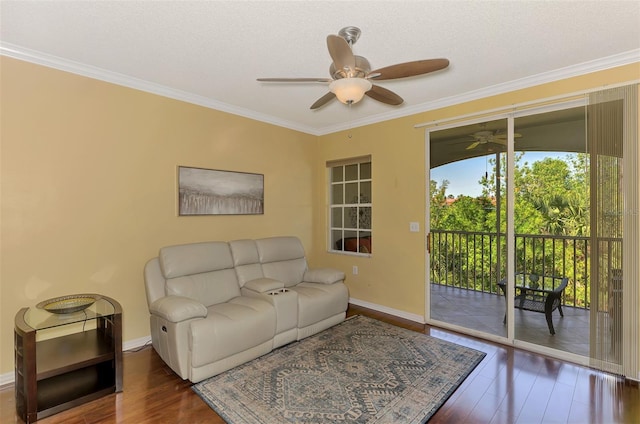 living room with baseboards, a ceiling fan, wood finished floors, and crown molding