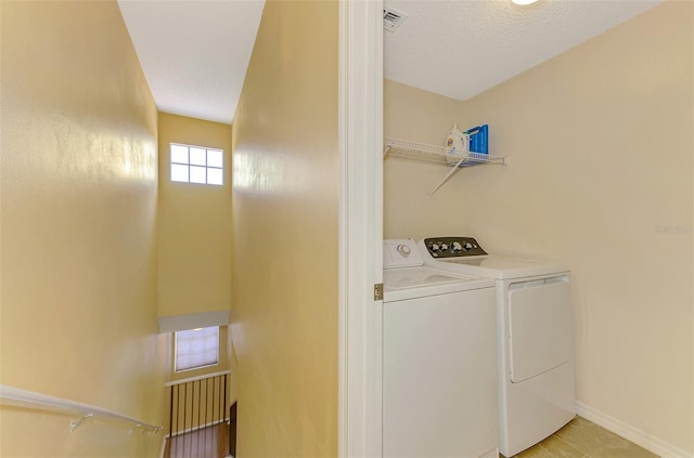 laundry area with washer and dryer, baseboards, laundry area, and visible vents