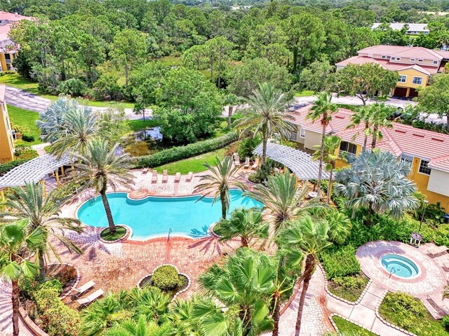 pool featuring a view of trees and a hot tub