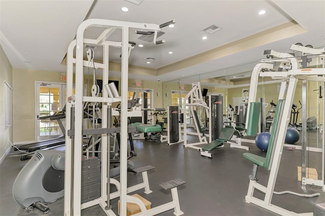 workout area featuring a raised ceiling, visible vents, and recessed lighting