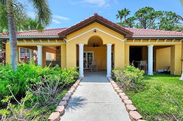doorway to property with a patio area, a ceiling fan, a tile roof, stucco siding, and french doors