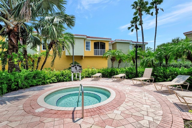 view of swimming pool featuring a community hot tub and a patio