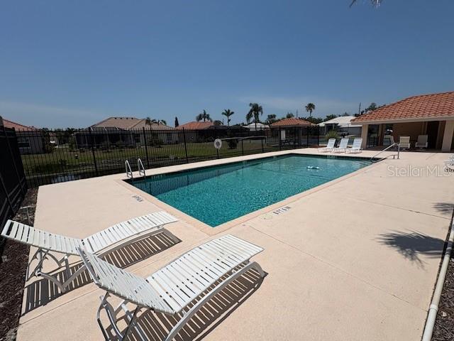 community pool featuring a patio and fence