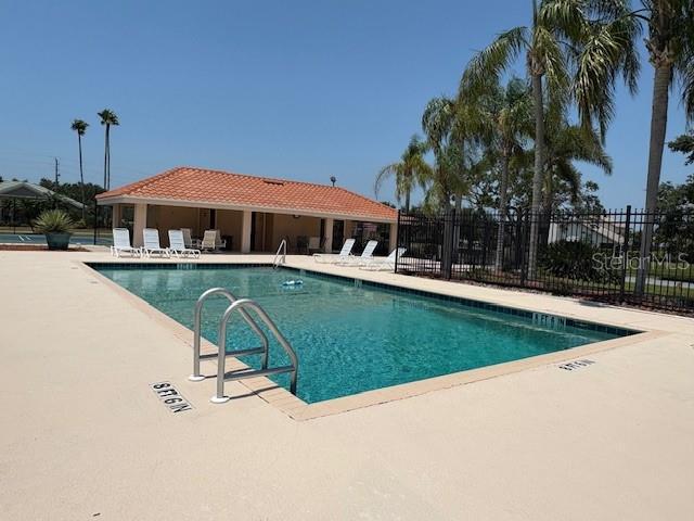pool with fence and a patio