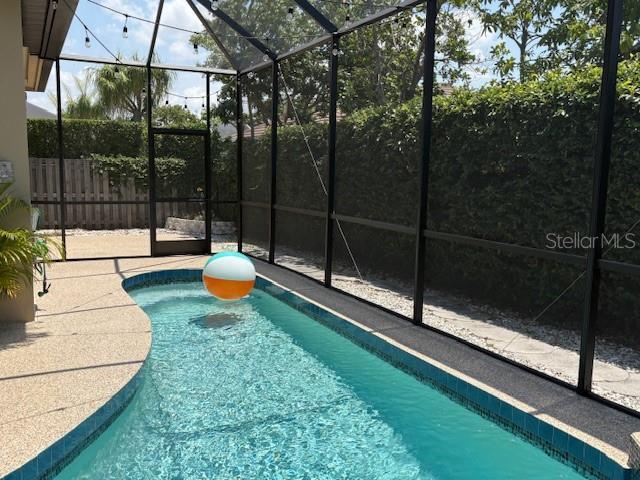 view of pool with a patio, a fenced in pool, and a lanai