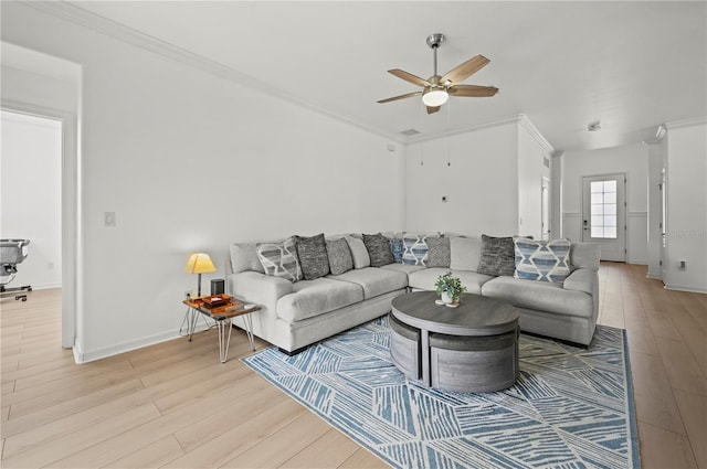 living room featuring baseboards, light wood-type flooring, ornamental molding, and ceiling fan