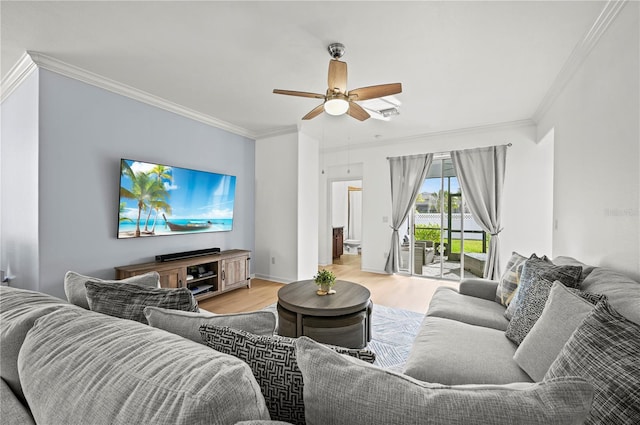 living area with light wood-type flooring, crown molding, a ceiling fan, and baseboards
