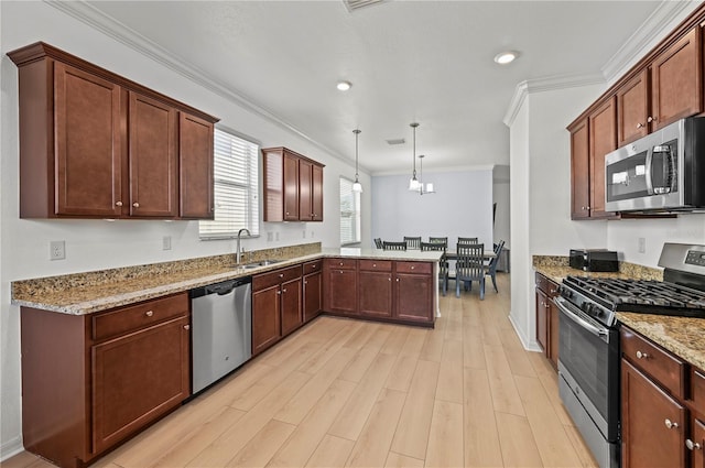 kitchen with a sink, a peninsula, light wood finished floors, stainless steel appliances, and light stone counters
