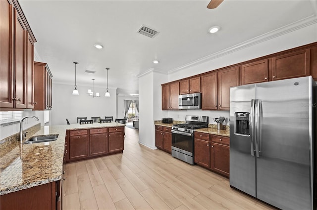 kitchen with visible vents, a sink, ornamental molding, appliances with stainless steel finishes, and a peninsula