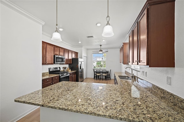 kitchen featuring ornamental molding, a peninsula, visible vents, appliances with stainless steel finishes, and a sink