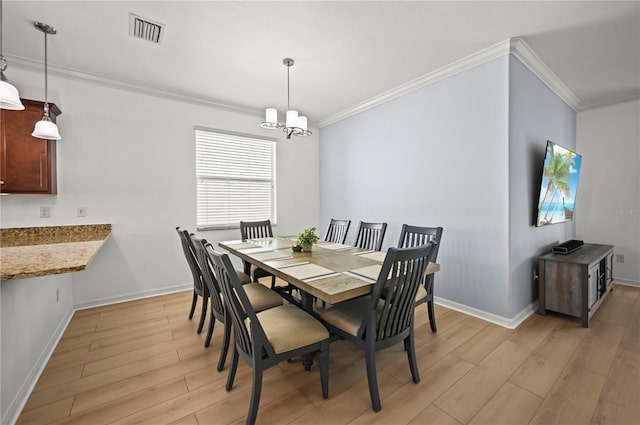 dining room with a chandelier, crown molding, visible vents, and light wood-type flooring