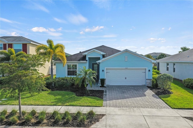 ranch-style home featuring a front yard, a garage, decorative driveway, and stucco siding