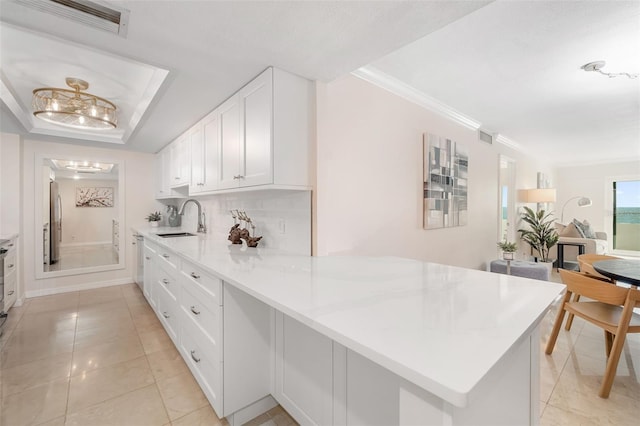 1750 Benjamin Franklin Dr Unit 6B, Sarasota, FL 34236 - kitchen featuring white cabinets, freestanding refrigerator, light tile patterned floors, light countertops, and ornamental molding