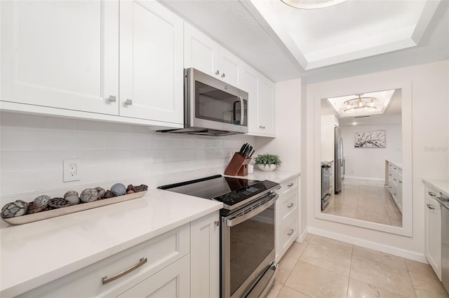 1750 Benjamin Franklin Dr Unit 6B, Sarasota, FL 34236 - kitchen featuring appliances with stainless steel finishes, white cabinetry, a chandelier, light tile patterned floors, and light stone countertops