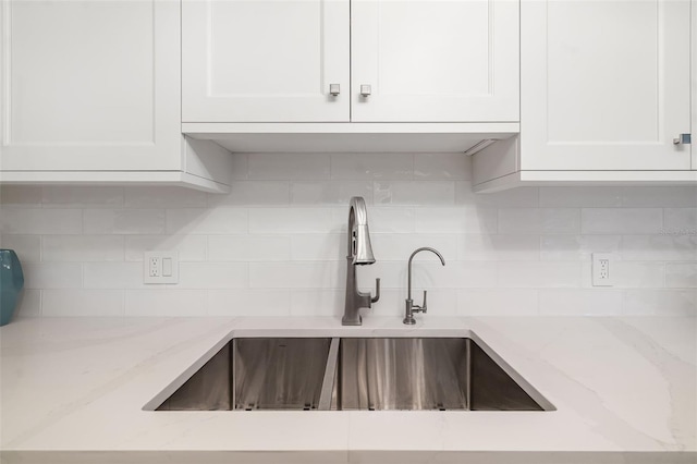 1750 Benjamin Franklin Dr Unit 6B, Sarasota, FL 34236 - kitchen with white cabinetry, tasteful backsplash, and light stone counters