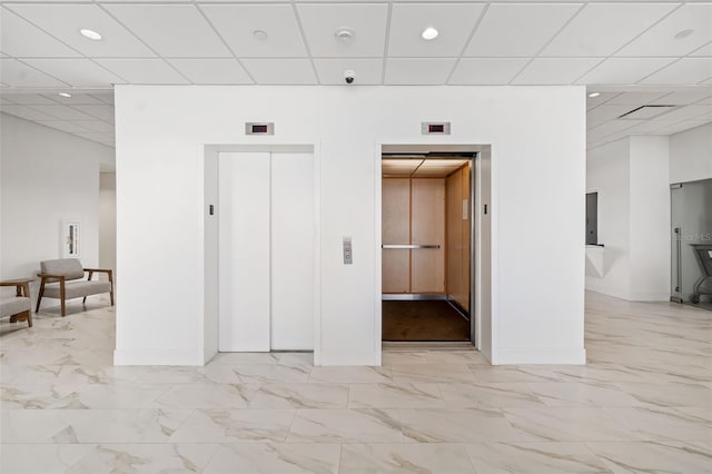 1750 Benjamin Franklin Dr Unit 6B, Sarasota, FL 34236 - empty room with elevator, a paneled ceiling, light marble finish floors, recessed lighting, and a smoke detector