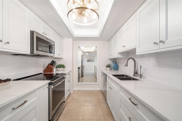 1750 Benjamin Franklin Dr Unit 6B, Sarasota, FL 34236 - kitchen featuring appliances with stainless steel finishes, tasteful backsplash, and white cabinets