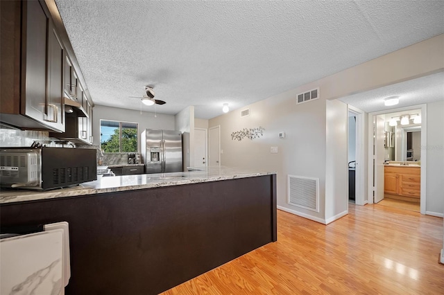 6033 34th St W Unit 132, Bradenton, FL 34210 - kitchen featuring stainless steel fridge with ice dispenser, dark brown cabinets, a ceiling fan, a peninsula, and a textured ceiling