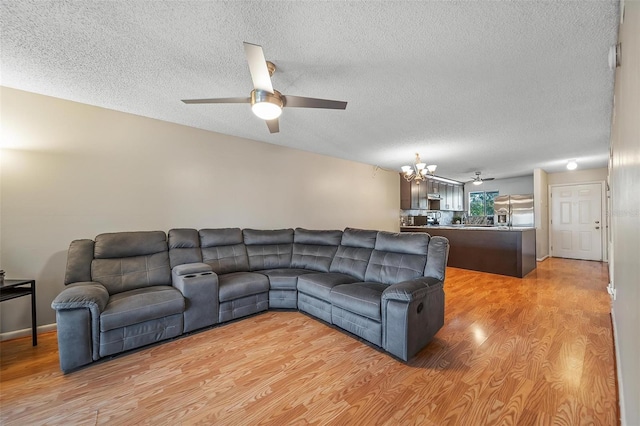 6033 34th St W Unit 132, Bradenton, FL 34210 - living room with ceiling fan, a chandelier, light wood-type flooring, and a textured ceiling