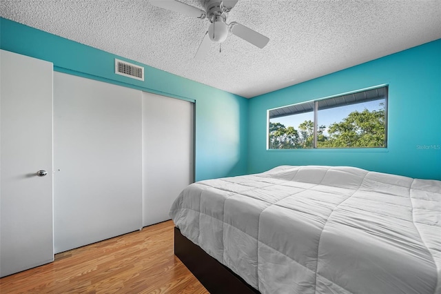 6033 34th St W Unit 132, Bradenton, FL 34210 - bedroom featuring a textured ceiling, wood finished floors, a closet, and ceiling fan