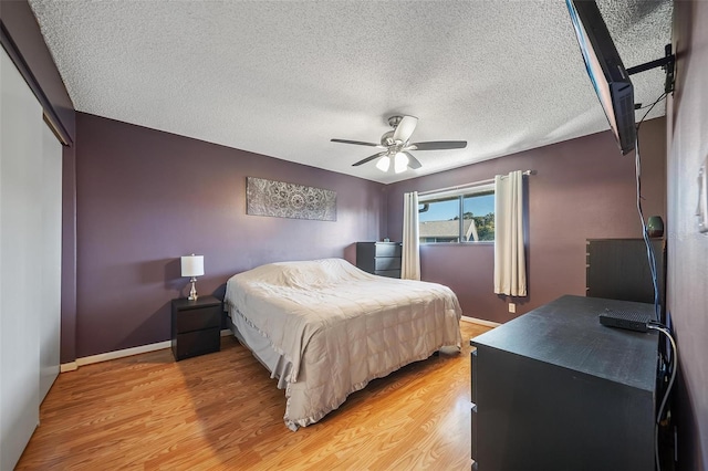 6033 34th St W Unit 132, Bradenton, FL 34210 - bedroom featuring light wood finished floors, a closet, a ceiling fan, a textured ceiling, and baseboards