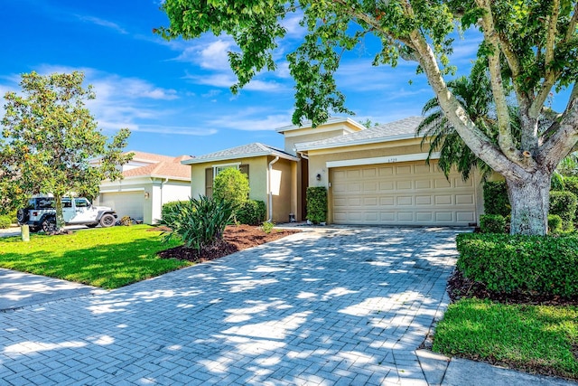 6729 45th Ter E, Bradenton, FL 34203 - view of front facade featuring a front yard, stucco siding, decorative driveway, and an attached garage