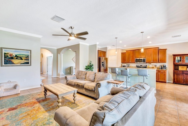 6729 45th Ter E, Bradenton, FL 34203 - living area featuring visible vents, a ceiling fan, arched walkways, and light tile patterned floors