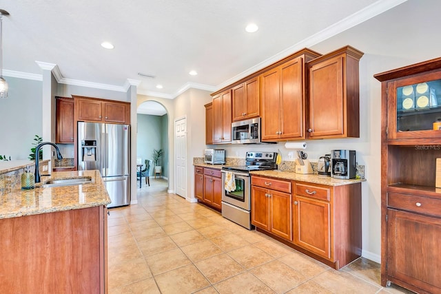 6729 45th Ter E, Bradenton, FL 34203 - kitchen with light stone counters, brown cabinets, stainless steel appliances, arched walkways, and a sink