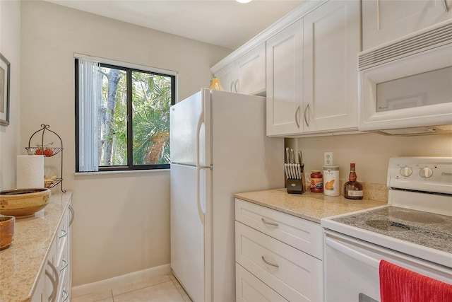kitchen featuring baseboards, white cabinetry, white appliances, light stone countertops, and light tile patterned floors