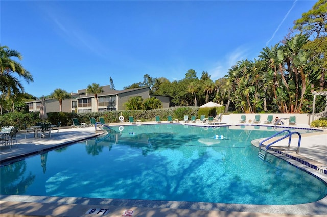 pool with a patio area and fence