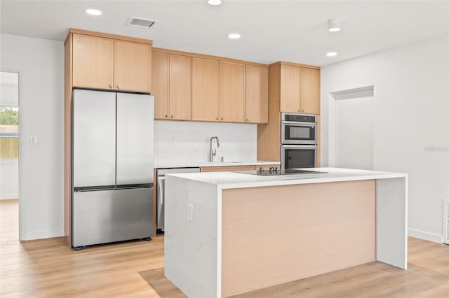 1050 55th Ave S, Saint Petersburg, FL 33705 - kitchen with stainless steel appliances, a sink, light brown cabinetry, light countertops, and recessed lighting