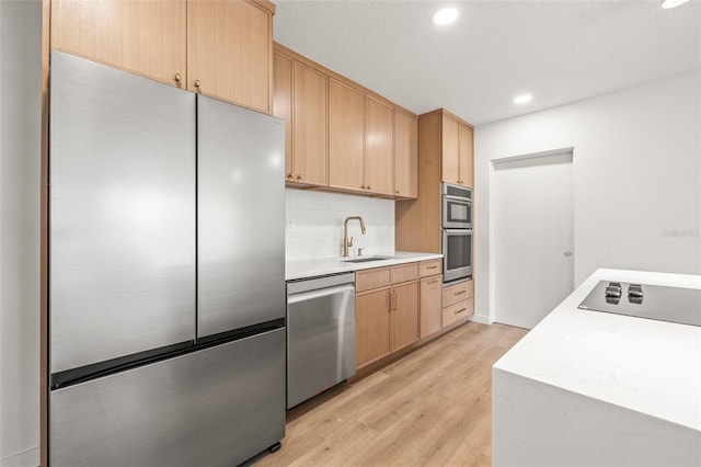 1050 55th Ave S, Saint Petersburg, FL 33705 - kitchen with stainless steel appliances, a sink, light wood-type flooring, light countertops, and light brown cabinets
