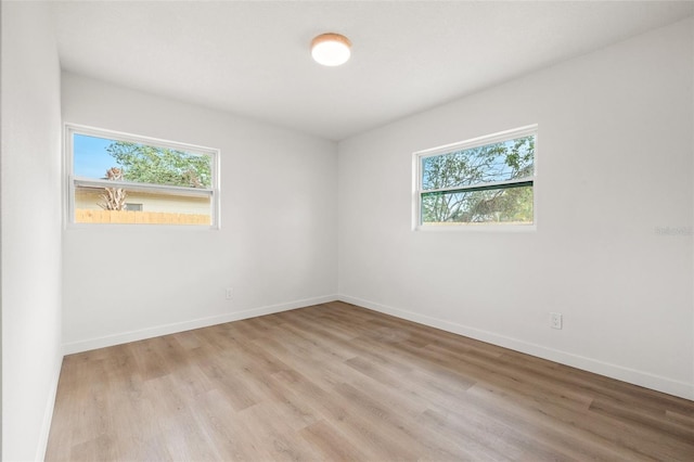 1050 55th Ave S, Saint Petersburg, FL 33705 - unfurnished room with light wood-style floors and baseboards