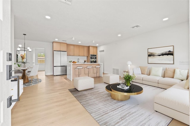 1050 55th Ave S, Saint Petersburg, FL 33705 - living area with light wood-style flooring, a chandelier, and recessed lighting