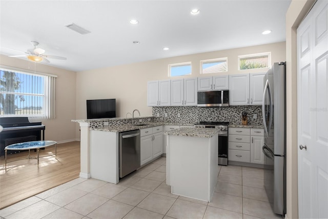 1322 Millbrook Cir, Bradenton, FL 34212 - kitchen with stainless steel appliances, backsplash, a sink, a kitchen island, and a peninsula