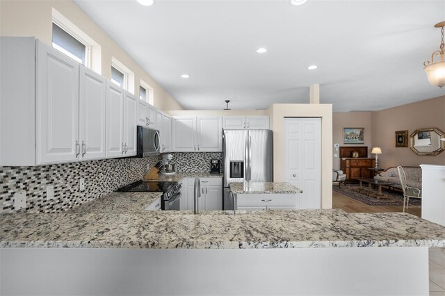 1322 Millbrook Cir, Bradenton, FL 34212 - kitchen with decorative light fixtures, light stone countertops, decorative backsplash, appliances with stainless steel finishes, and white cabinetry