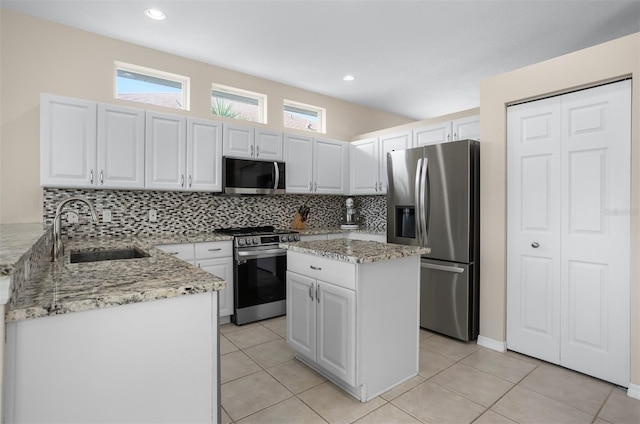 1322 Millbrook Cir, Bradenton, FL 34212 - kitchen with stainless steel appliances, a sink, white cabinetry, decorative backsplash, and light stone counters