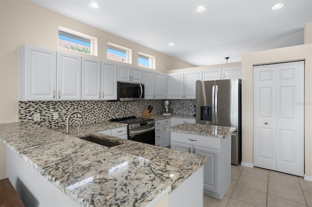 1322 Millbrook Cir, Bradenton, FL 34212 - kitchen with light stone counters, stainless steel appliances, a sink, a peninsula, and tasteful backsplash