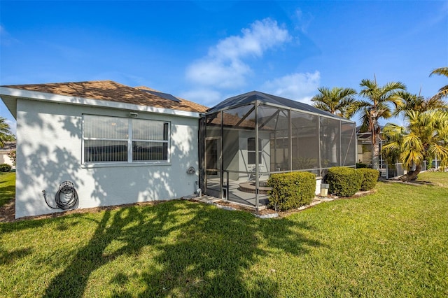 1322 Millbrook Cir, Bradenton, FL 34212 - back of property featuring glass enclosure, a yard, roof mounted solar panels, and stucco siding
