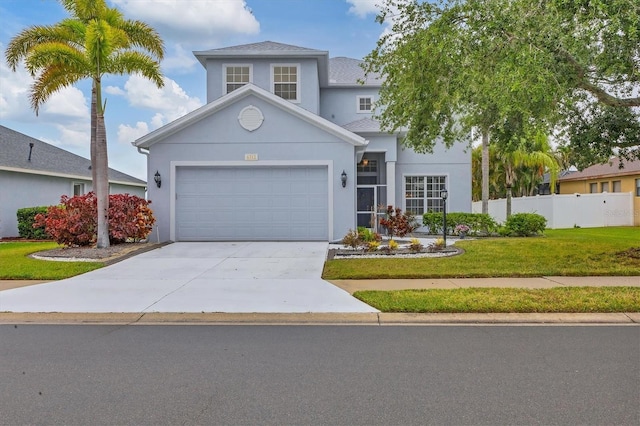 traditional home featuring a front yard, an attached garage, fence, stucco siding, and driveway