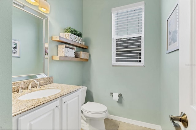bathroom featuring tile patterned floors, vanity, baseboards, and toilet