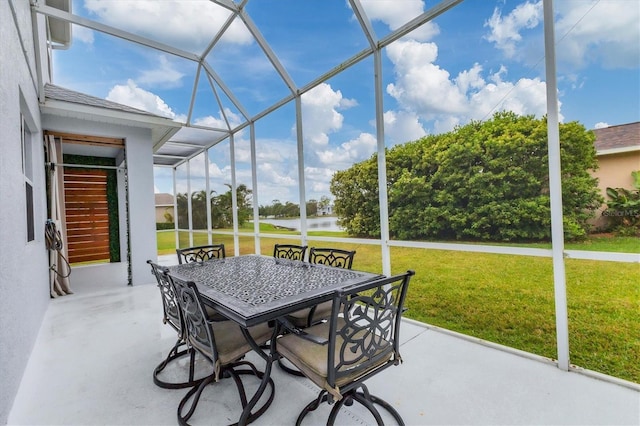 sunroom / solarium featuring a water view and outdoor dining area