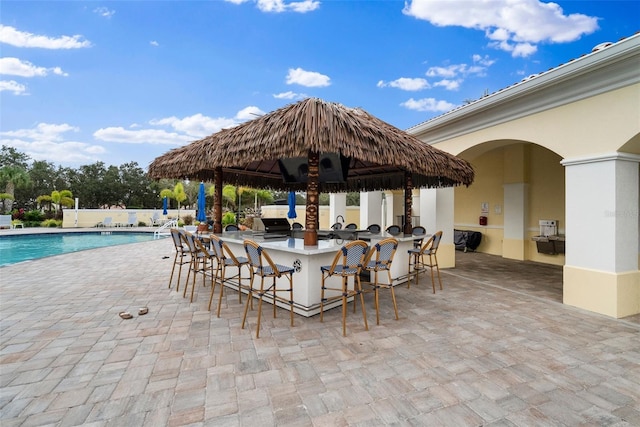 exterior space featuring a community pool and outdoor wet bar