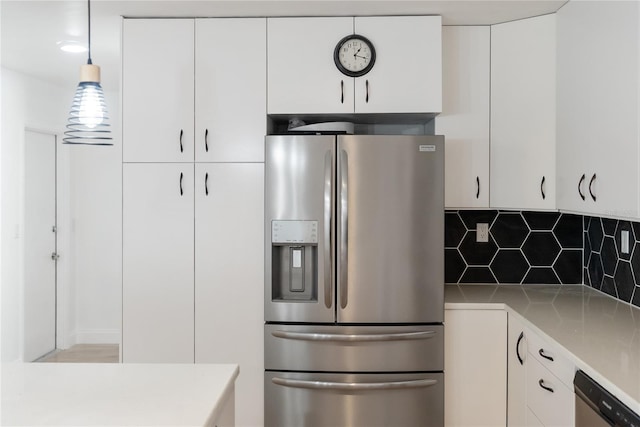 kitchen with backsplash, white cabinets, appliances with stainless steel finishes, and light countertops