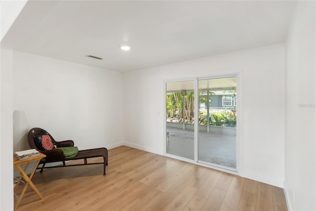 sitting room featuring light wood-type flooring, baseboards, visible vents, and recessed lighting